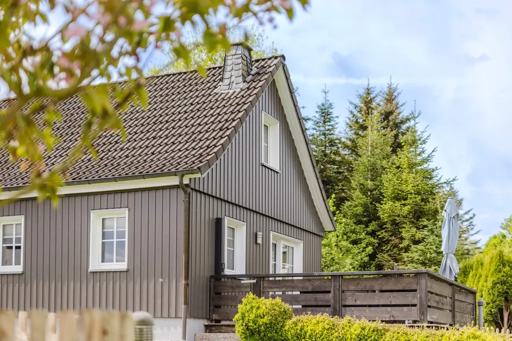 Außenansicht des Ferienhauses mit großer Holzterrasse und Garten