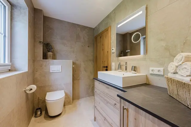 Badezimmer im Ferienhaus mit WC und beleuchtetem Spiegel