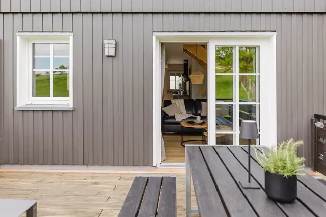 Terrasse mit Gartentisch und Bänken vor dem Eingang des Ferienhauses