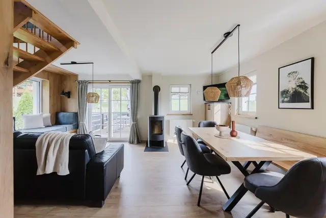 Offener Wohn- und Essbereich im Ferienhaus mit Kaminofen und Ledersofa