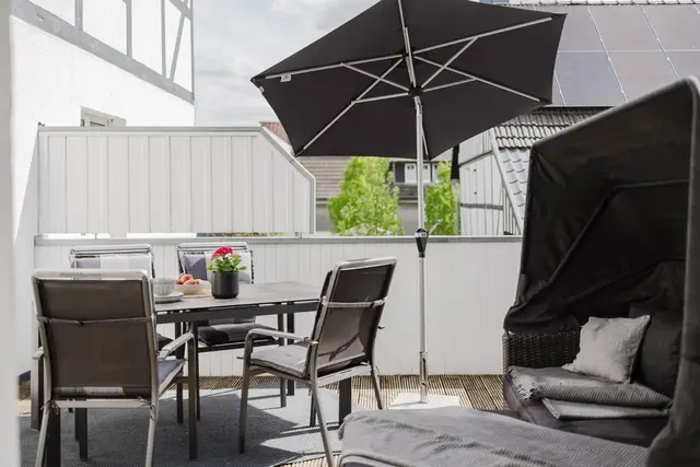Terrasse der Ferienwohnung mit Sitzgruppe, Sonnenschirm und Strandkorb
