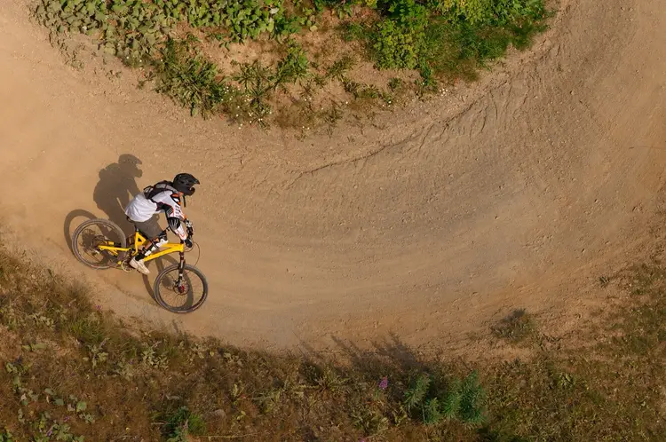 Mountainbiker in einer Steilkurve im Bikepark Winterberg, von oben fotografiert